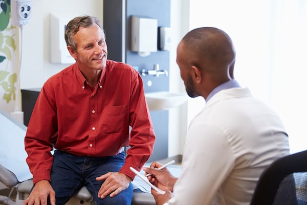 A healthcare professional provides a clinical trial participant with tips on how to manage their health, alongside treatment plans